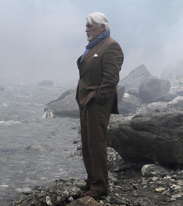 Richard (Mario Adorf) am Fluss, er hat seine Waffe dabei. 