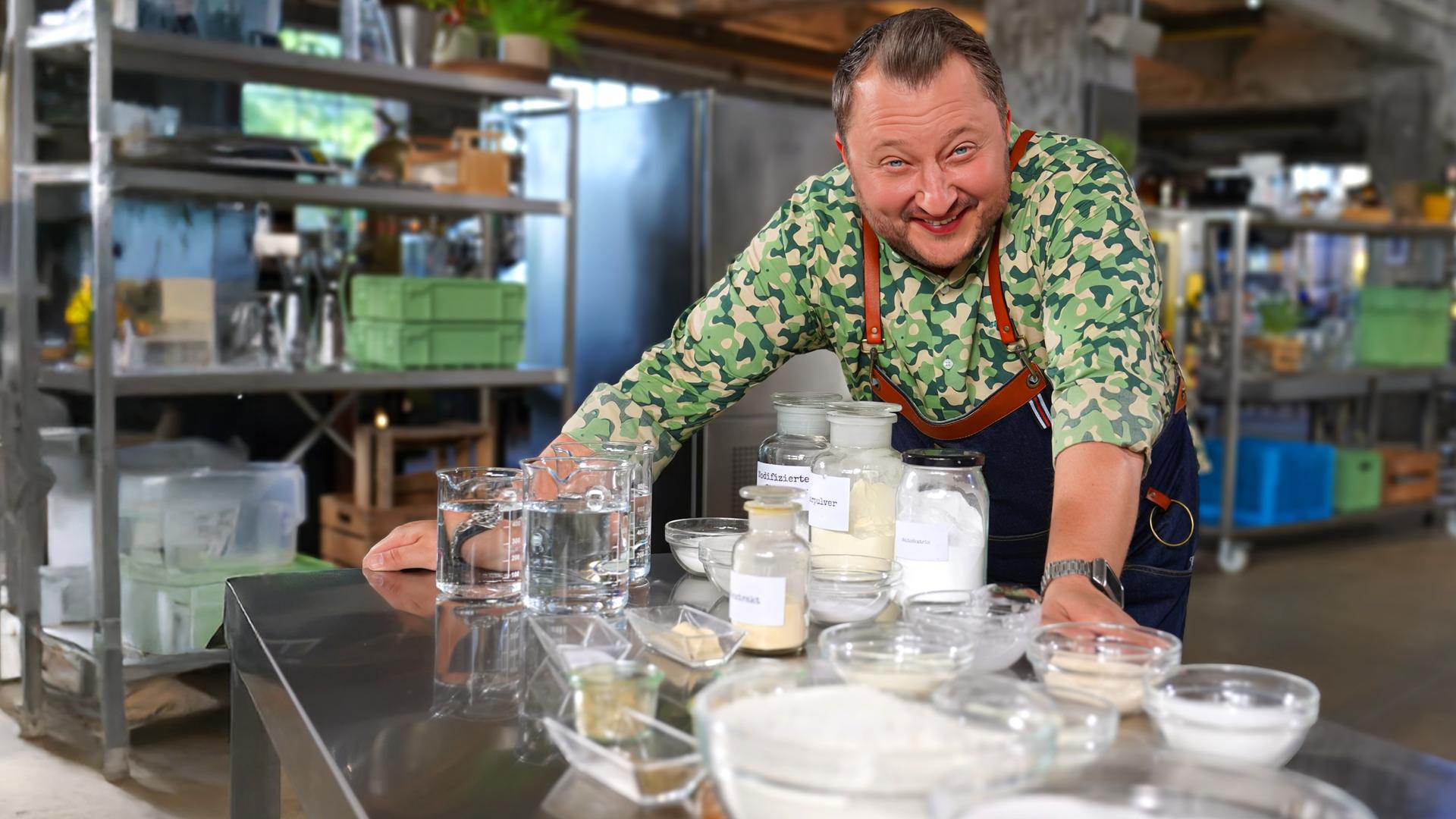 Sebastian Lege steht in seiner Werkstatt vor Produkten und Zutaten