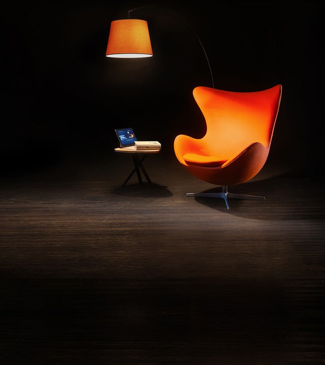 Ein Sessel, ein Beistelltisch und eine Leselampe auf einer sonst dunklen Bühne