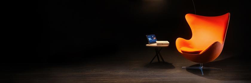 Ein Sessel, ein Beistelltisch und eine Leselampe auf einer sonst dunklen Bühne