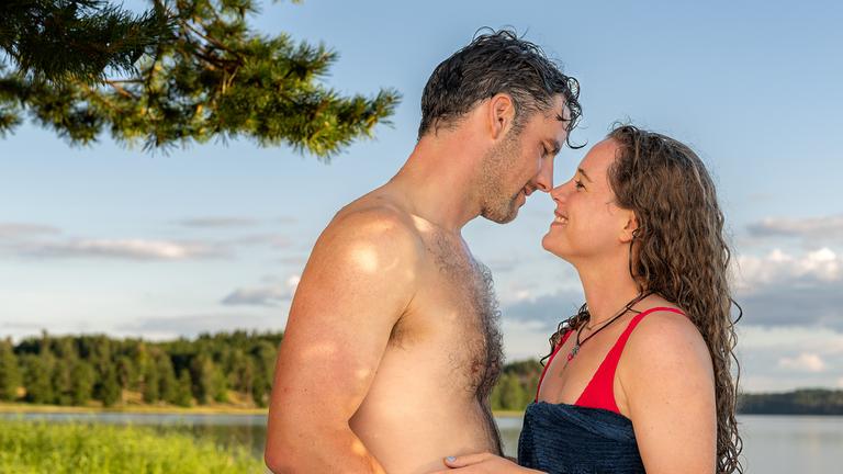 Jule (Klara Deutschmann) und Paul (Ferdinand Seebacher) kommen sich näher. "Inga Lindström: Liebst du mich?": Jule (Klara Deutschmann) und Paul (Ferdinand Seebacher) stehen sich am Ufer eines Sees gegenüber. Paul trägt eine Badehose und hält ein Handtuch in der rechten Hand. Jule trägt einen Badeanzug und hat ihr Handtuch um den Körper gebunden. Jule lächelt, es scheint, als wollten beide sich küssen.