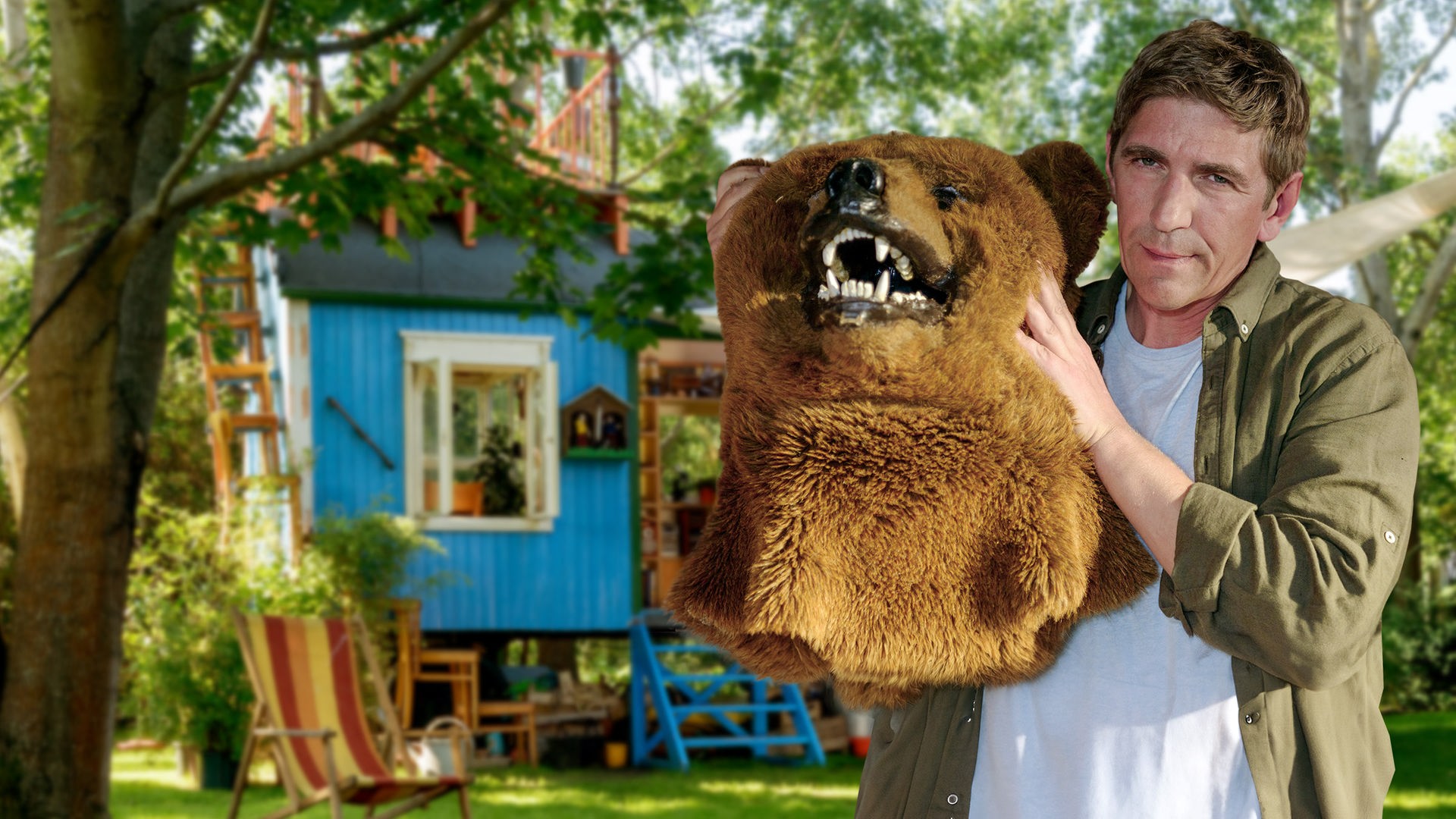 Fritz Fuchs hält das Oberteil eines Bärenkostüms mit Bärenkopf in den Händen