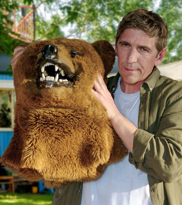 Fritz Fuchs hält das Oberteil eines Bärenkostüms mit Bärenkopf in den Händen