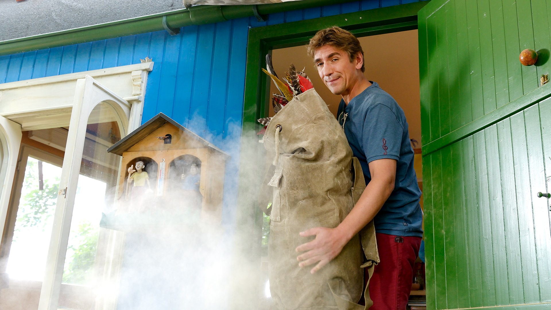 Fritz steht auf der Bauwagentreppe und hat einen großen Sack im Arm