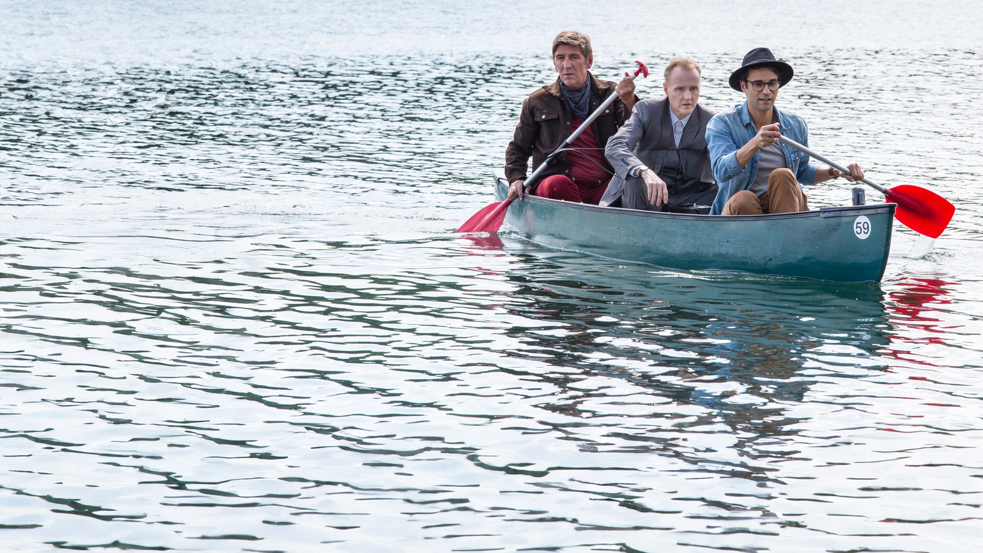 Fritz paddelt mit Kluthe und Joseph “Flying Bear” Hawkings in einem Kanu über einen See