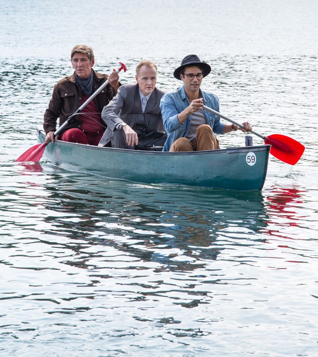 Fritz paddelt mit Kluthe und Joseph “Flying Bear” Hawkings in einem Kanu über einen See