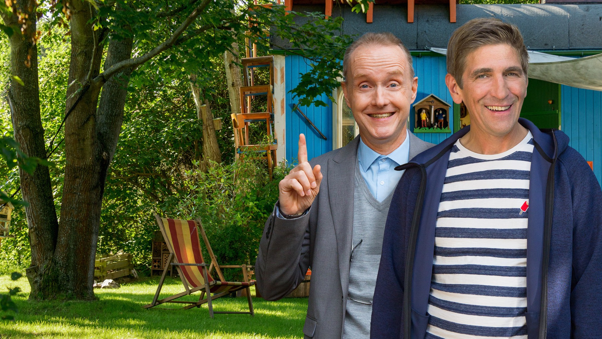 Fritz und Kluthe stehen vor dem Bauwagen und lachen in die Kamera