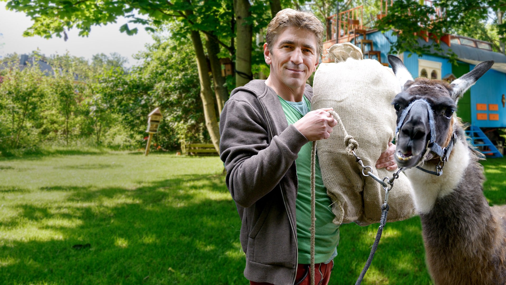 Fritz Fuchs steht mit einem Lama vor dem Bauwagen