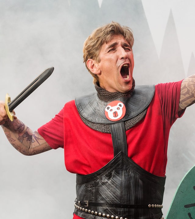 Fritz Fuchs, als König verkleidet mit einem Schwert in der Hand, singt