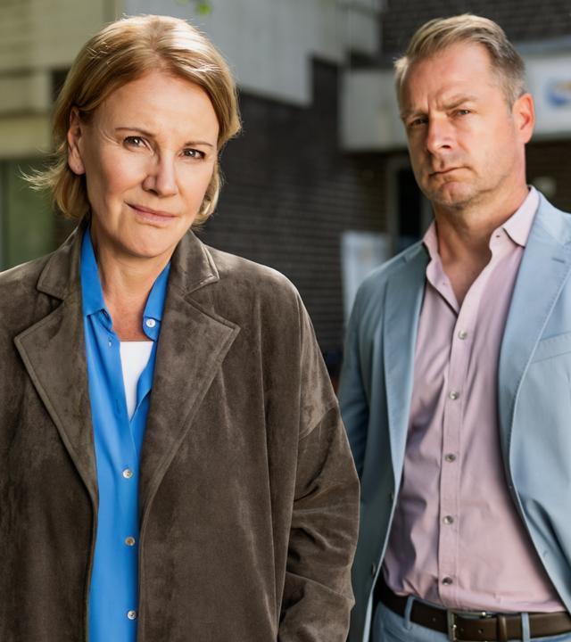  Marie Brand (Mariele Millowitsch) steht zusammen mit Jürgen Simmel (Hinnerk Schönemann) vor dem Eingang eines Kinderhorts.