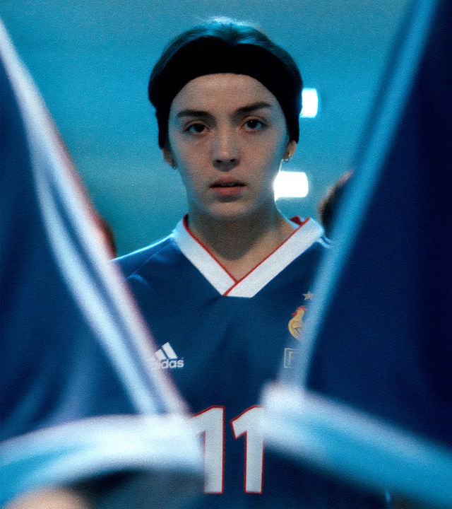 Marinette (Garance Marillier) steht zwischen anderen Spielerinnen im Tunnel eines Stadions. Alle tragen das Trikot der Nationalmannschaft.