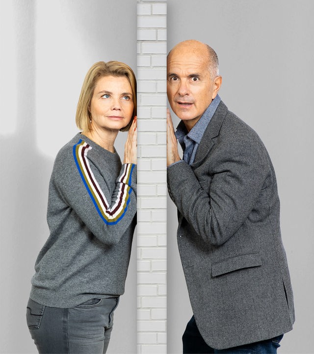 Anne (Annette Frier) und Erik (Christoph Maria Herbst) stehen auf der jeweils anderen Seite einer Wand und halten ihr Ohr gegen diese.