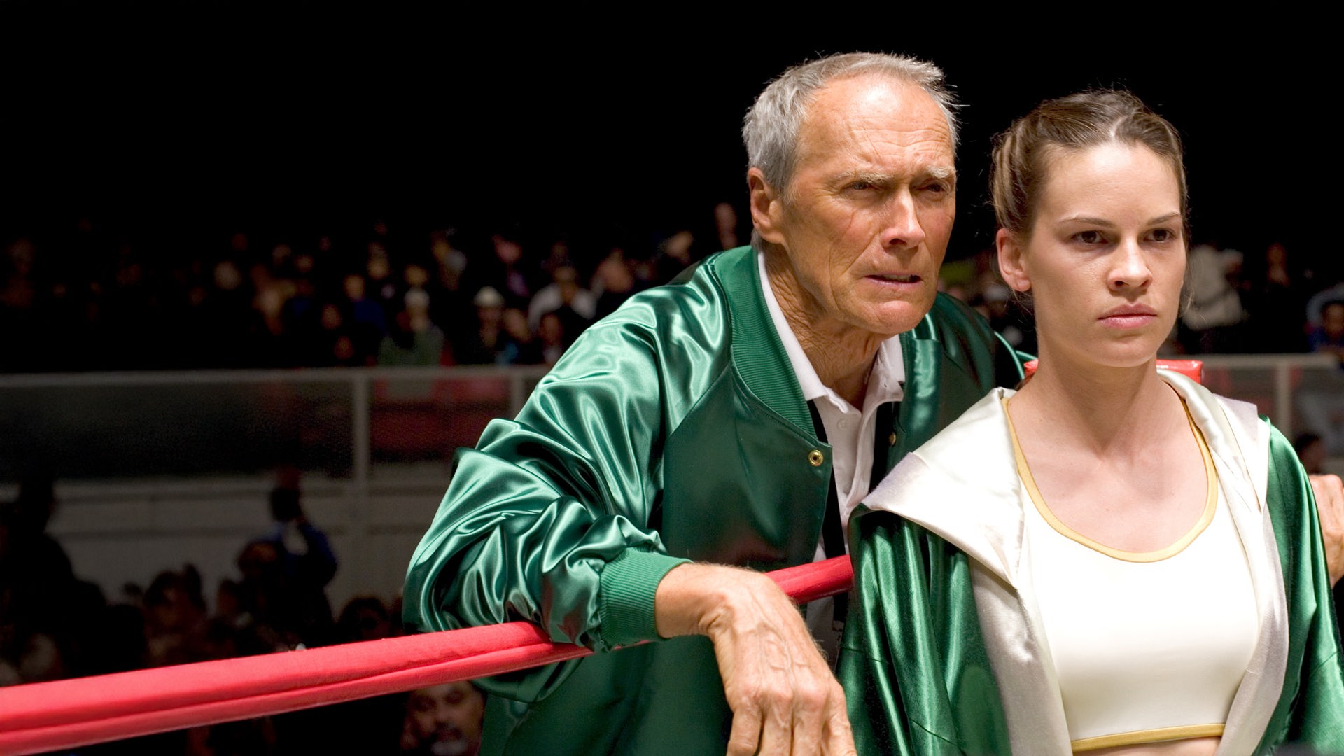 "Million Dollar Baby": Frankie (Clint Eastwood) steht hinter Maggie (Hilary Swank) in der Ecke eines Boxrings. Beide tragen grüne Trainings-Jacken und schauen entschlossen nach vorn.