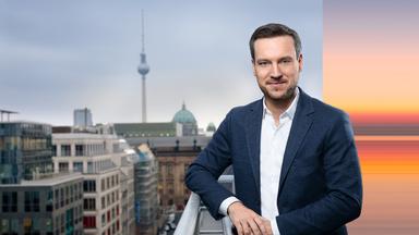 Andreas Wunn steht auf einer Dachterasse in Berlin und schaut in die Kamera. Im Hintergrund sieht man den Fernsehturm.