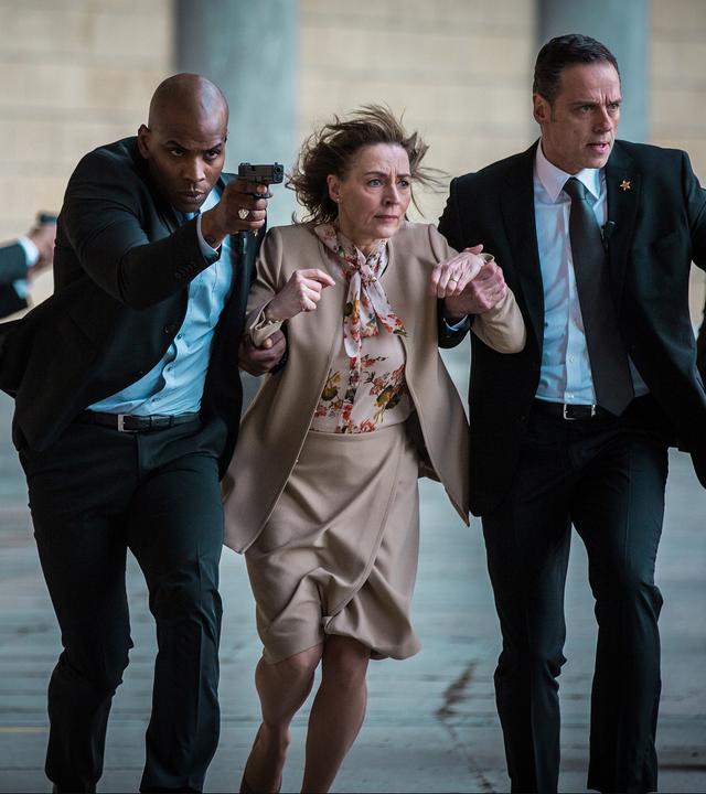 "Mord auf höchster Ebene": Die US-Präsidentin (Saskia Reeves) wird von dem Sicherheitschef der US-Delegation (Adam Dodley) und seinen Mitarbeitern in Sicherheit gebracht.