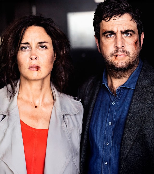 Julia Lehmann (Susanne Wolff) und ihr Mann Jochen (Bastian Pastewka) schauen den Betrachter entschlossen an. Sie sehen allerdings ziemlich angeschlagen aus: sie haben blutige Lippen und Jochen eine Verletzung auf der linken Wange.