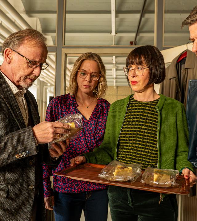 Ludwig Schaller (Alexander Held), Angelika Flierl (Bernadette Heerwagen), Dr. Linda Hösl (Eva Karl Faltermeier) und Harald Neuhauser (Marcus Mittermeier) stehen im Büro beisammen. Ludwig begutachtet einen Kuchen in seiner Hand. Die anderen drei beobachten ihn dabei, wobei Linda ein Tablet mit weiteren Kuchen in der Hand hält.