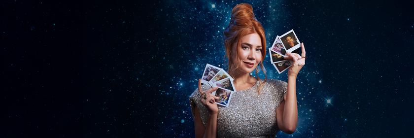 Ivy (Palina Rojinski) steht in einem langen roten Kleid vor einem großen roten Samtherz in dem einige Pfeile stecken. Sie hält einen Pfeil in ihren Händen.