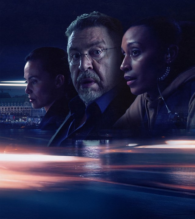 Das Bild zeigt die drei Hamburger Kriminalbeamten Tülay Yildrim (İdil Üner), Erich Bo Erichsen (Armin Rohde) und Lulu Koulibaly (Sabrina Ceesay), die besorgt vor einer nächtlichen Stadtkulisse zur Seite blicken. Der untere Teil des Plakats wird von dynamischen, hellen Lichtspuren auf einem dunklen Hintergrund dominiert.