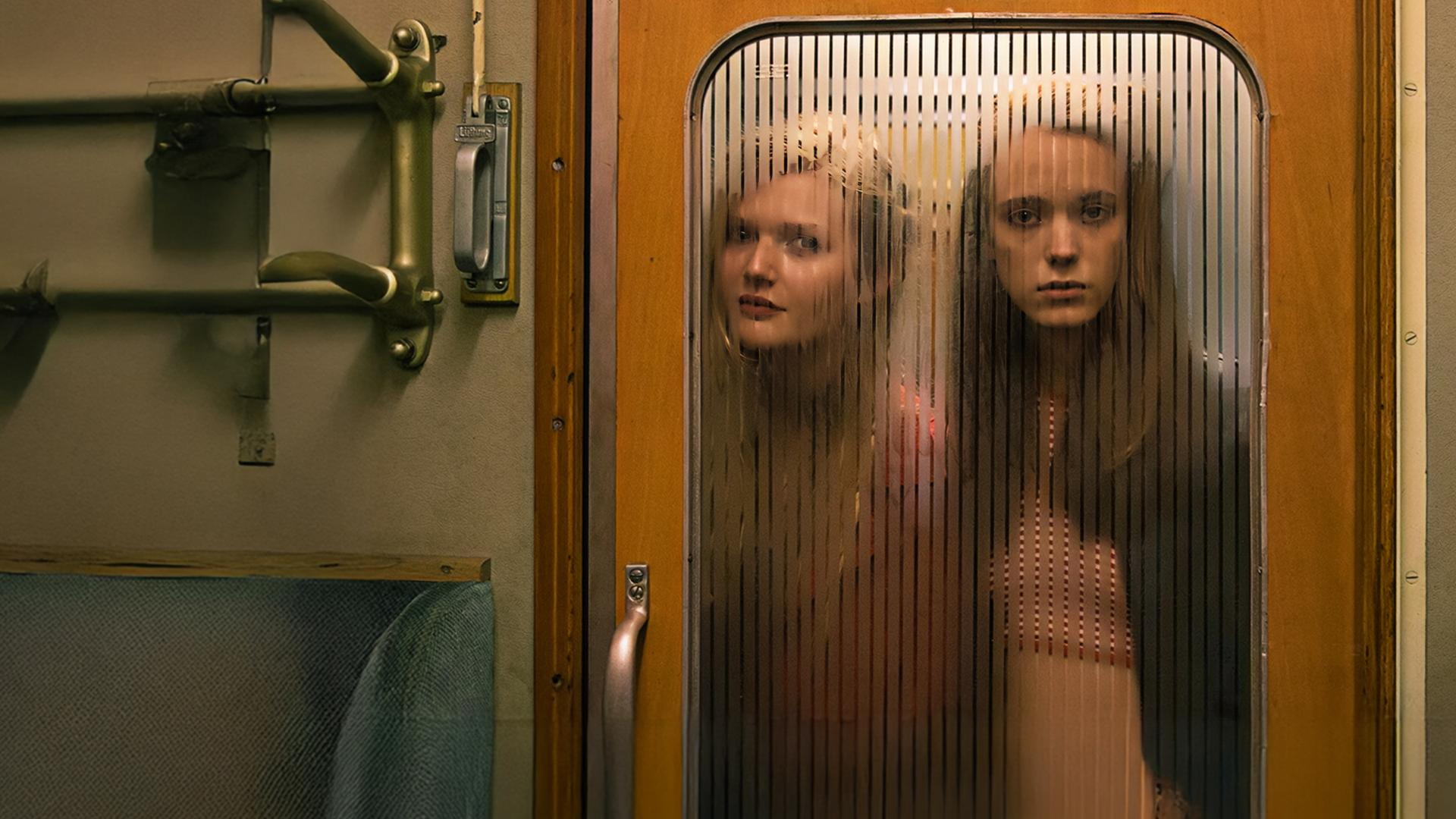 Joe (Stacy Martin, r.) und Schulfreundin B (Sophie Kennedy Clark) blicken durch die Glastür eines Zuges in die 1. Klasse.