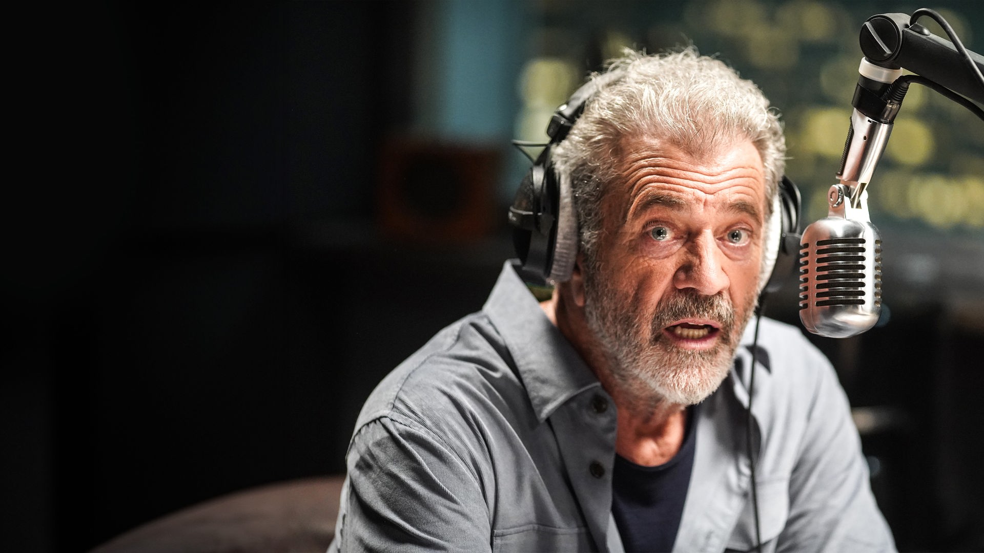 Der Radiomoderator Elvis (Mel Gibson) wird telefonisch von einem Geiselnehmer und Bombenleger erpresst. "On the Line": Nahaufnahme: Elvis (Mel Gibson) sitzt mit Kopfhörern und entsetztem Gesichtsausdruck vor einem Mikrofon.