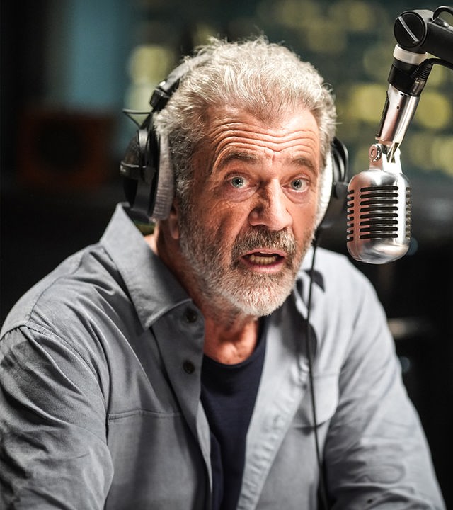 Der Radiomoderator Elvis (Mel Gibson) wird telefonisch von einem Geiselnehmer und Bombenleger erpresst. "On the Line": Nahaufnahme: Elvis (Mel Gibson) sitzt mit Kopfhörern und entsetztem Gesichtsausdruck vor einem Mikrofon.