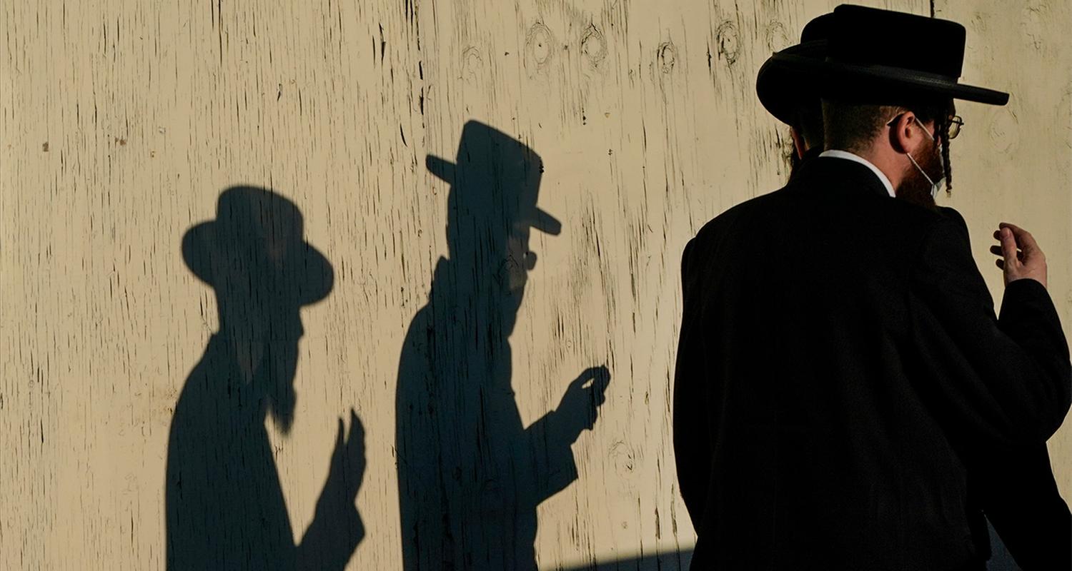 Orthodoxe Juden laufen an Mauer vorbei