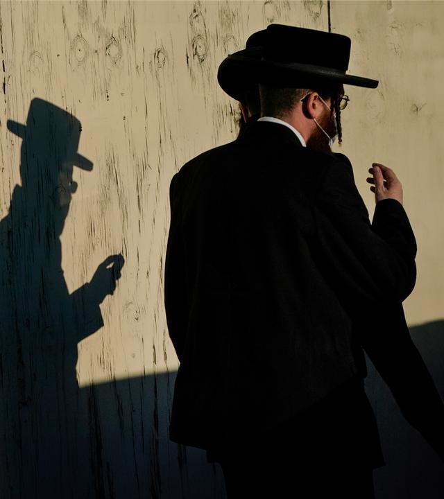 Orthodoxe Juden laufen an Mauer vorbei