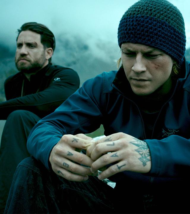 "Point Break": Johnny Utah (Luke Bracey) und Bodhi (Édgar Ramírez, l.) sitzen nebeneinander auf einem Berggipfel und blicken konzentriert vor sich hin.
