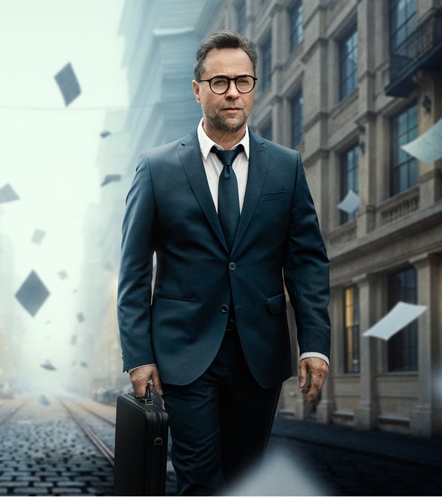 Rechtsanwalt Joachim Vernau (Jan Josef Liefers) läuft in durch die Straßen von Berlin. Er trägt einen schicken schwarzen Anzug, eine schwarze Krawatte und einen Aktenkoffer. Die Häuser auf der linken Seite und im Hintergrund, der Straßenschlucht durch die er läuft, bestehen aus Akten und Papierstapeln. Auch um den Anwalt selbst fliegen einzelne Aktenseiten heraum als wären sie Laub an einem windigen Herbsttag.