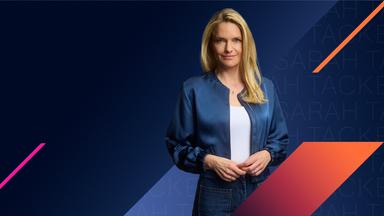 Sarah Tacke schaut selbstbewusst in die Kamera. Hinter ihr ist ein grafischer Hintergrund in blauen Farbklima mit orangenen und magentanen Akzenten zu sehen