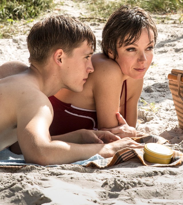 Christian (Jonas Nay) und Stella (Julia Koschitz) genießen die Zeit zu zweit. Sie dürfen dabei nur nicht entdeckt werden. "Schweigeminute": Christian (Jonas Nay) und Stella Petersen liegen zusammen am Strand.