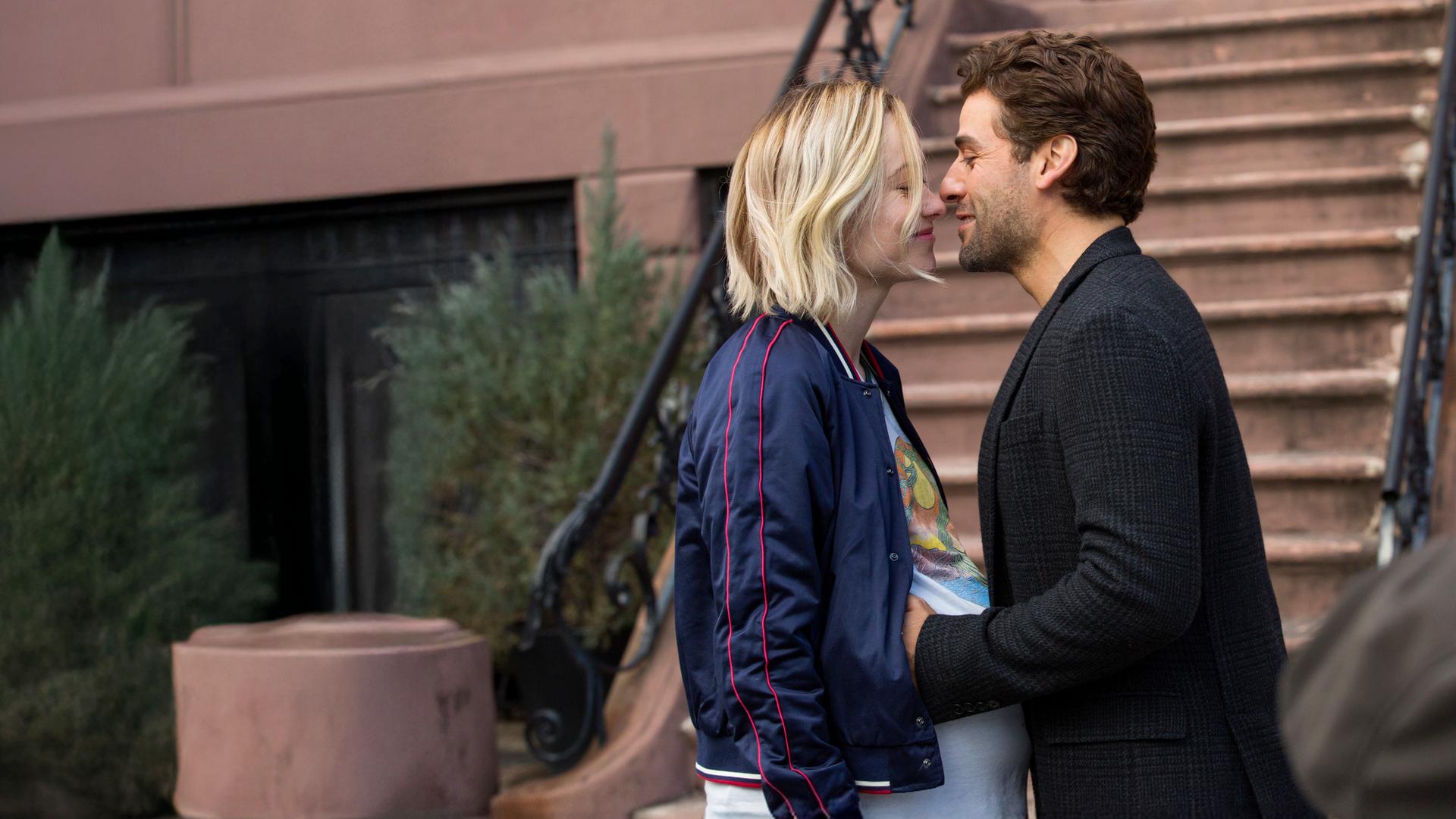 Die hochschwangere Abby (Olivia Wilde) und Will (Oscar Isaac) stehen sich vor einer Außentreppe gegenüber und blicken sich verliebt an. 