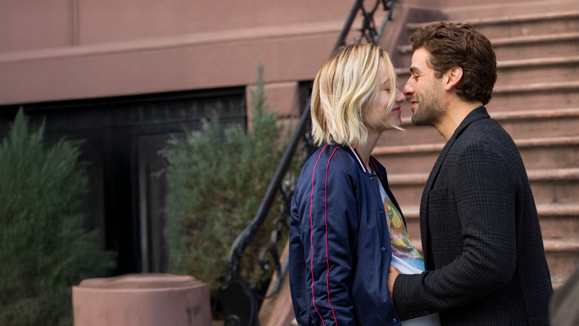 Die hochschwangere Abby (Olivia Wilde) und Will (Oscar Isaac) stehen sich vor einer Außentreppe gegenüber und blicken sich verliebt an. 