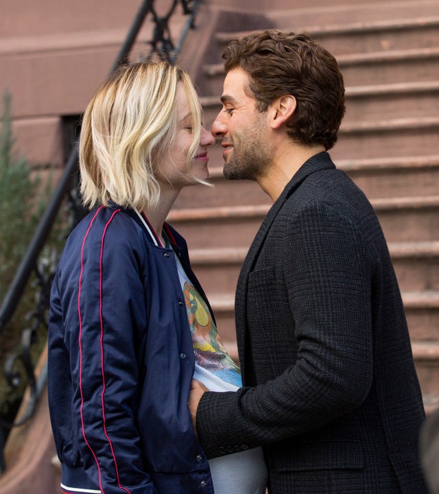 Die hochschwangere Abby (Olivia Wilde) und Will (Oscar Isaac) stehen sich vor einer Außentreppe gegenüber und blicken sich verliebt an. 
