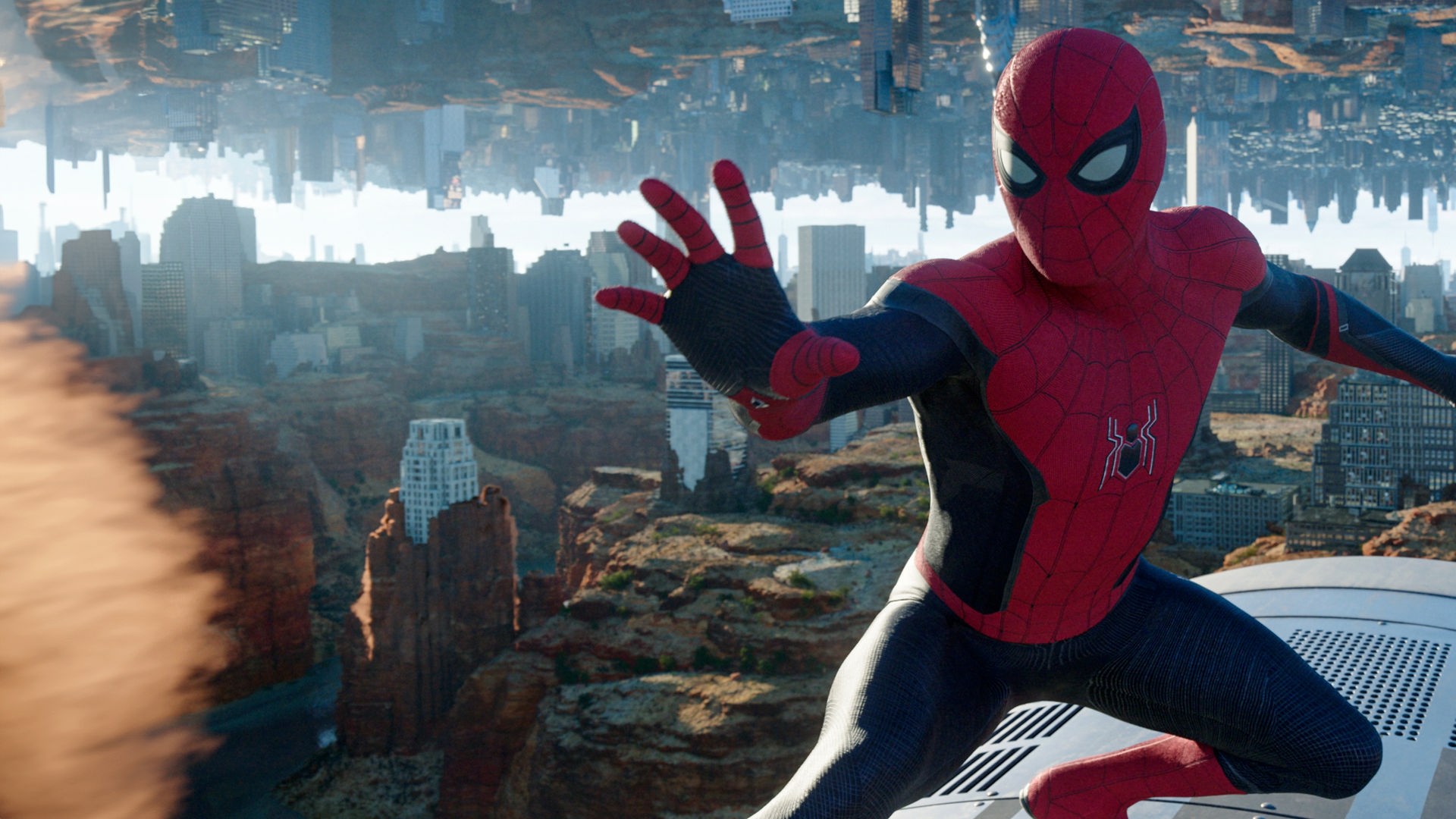 "Spider-Man: No Way Home": Spider-Man (Tom Holland) hält den mysteriösen Würfel von Doctor Strange in einer Hand. Hinter ihm ist ein New York, das zum Teil in einer Felslandschaft steht und im Himmel seitenverkehrt gespiegelt wird.