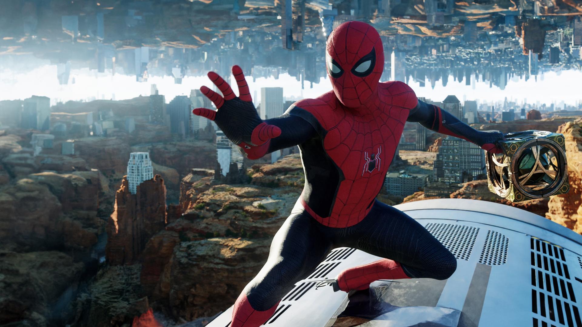 "Spider-Man: No Way Home": Spider-Man (Tom Holland) hält den mysteriösen Würfel von Doctor Strange in einer Hand. Hinter ihm ist ein New York, das zum Teil in einer Felslandschaft steht und im Himmel seitenverkehrt gespiegelt wird.