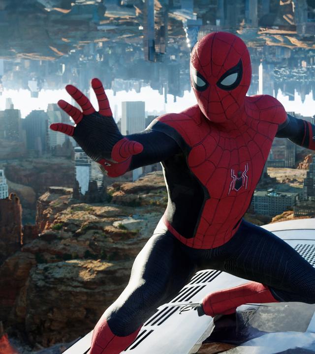 "Spider-Man: No Way Home": Spider-Man (Tom Holland) hält den mysteriösen Würfel von Doctor Strange in einer Hand. Hinter ihm ist ein New York, das zum Teil in einer Felslandschaft steht und im Himmel seitenverkehrt gespiegelt wird.