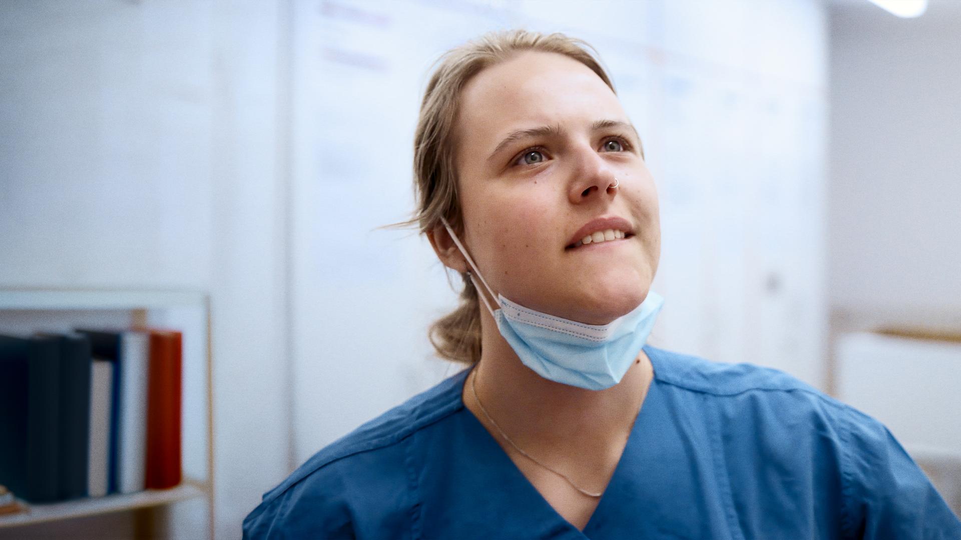 Pflegerin Anna, 24, im Kasack, auf dem Flur der pneumologischen Intensivstation.