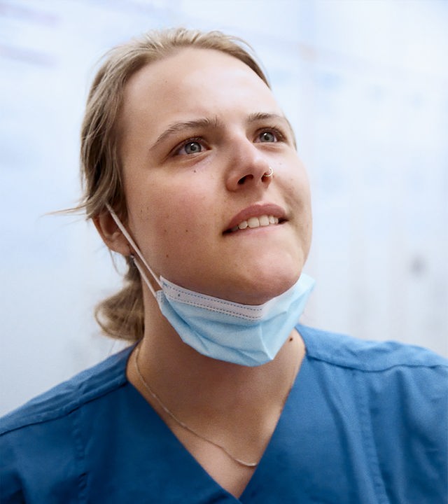 Pflegerin Anna, 24, im Kasack, auf dem Flur der pneumologischen Intensivstation.