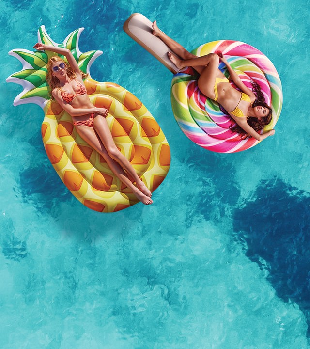 Chloe (Katherine McNamara) (links) und Melanie (Jasmine Sky Sarin) (rechts) liegen auf Luftmatratzen in Form einer Ananass und eines Lolipops auf der Wasseroberfläche.