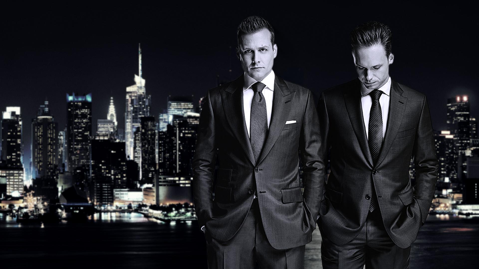 Star-Anwalt Harvey Specter und der clevere Mike Ross stehen nachts in teuren Anzügen vor der New Yorker Skyline.