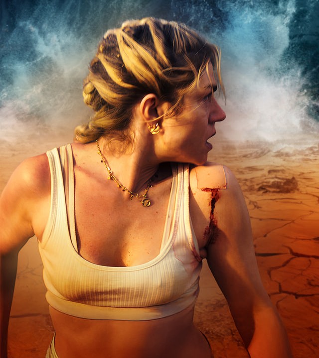 Filmposter zu einem Survival-Thriller, auf dem eine blonde Frau im weißen Trägertop mit einer blutenden Wunde an der Schulter zu sehen ist. Sie blickt alarmiert nach rechts über ihre Schulter, während im Hintergrund eine rissige, ausgetrocknete Wüstenlandschaft unter einem stürmischen Himmel liegt.