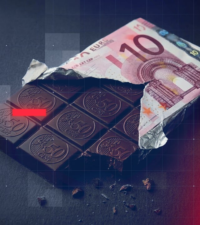 Eine Tafel Schokolade mit einer Umverpackung, auf der ein 10-Euro-Schein abgebildet ist. Die einzelnen Schokostücke tragen eine Prägung im Stil einer 50-Cent-Münze.