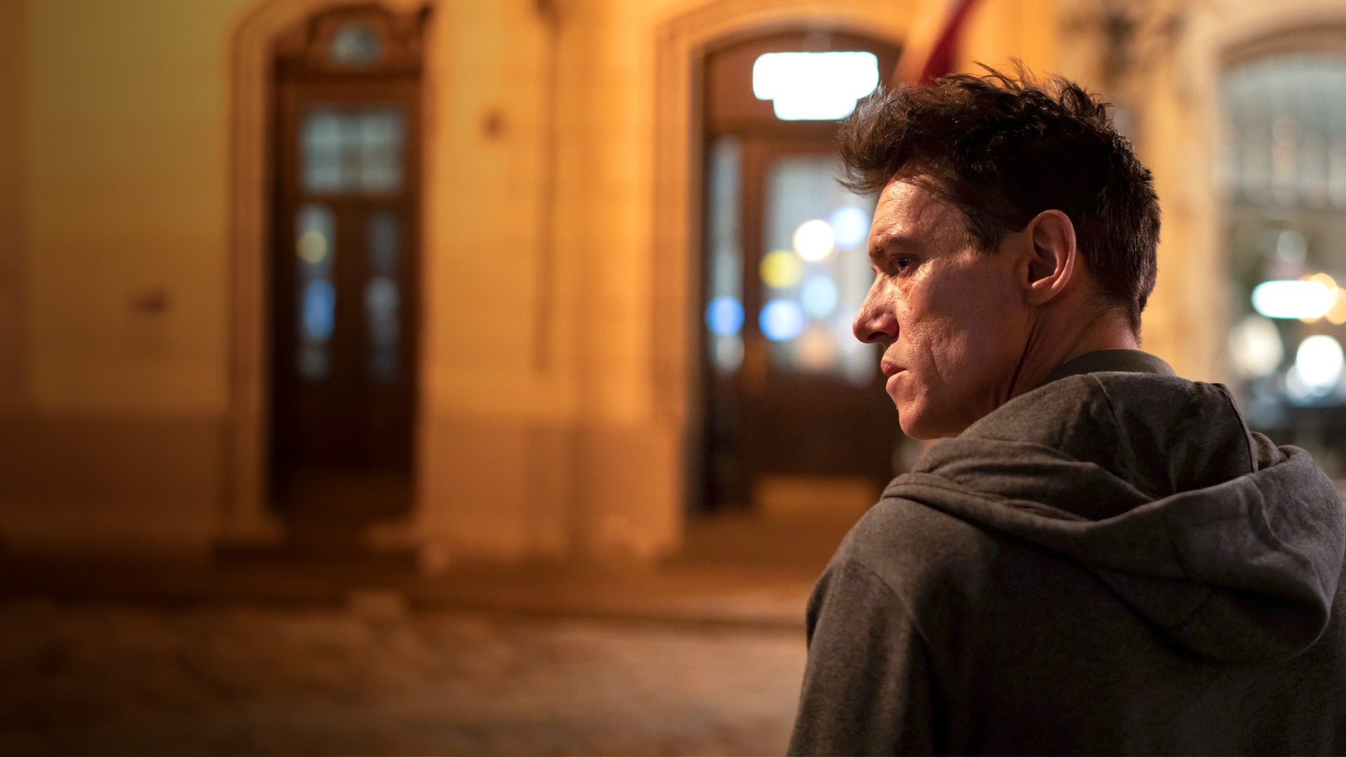 "The Good Neighbor": Nahaufnahme: Robert (Jonathan Rhys Meyers) steht von der Kamera abgekehrt und mit finsterem Blick in nächtlicher Straße.