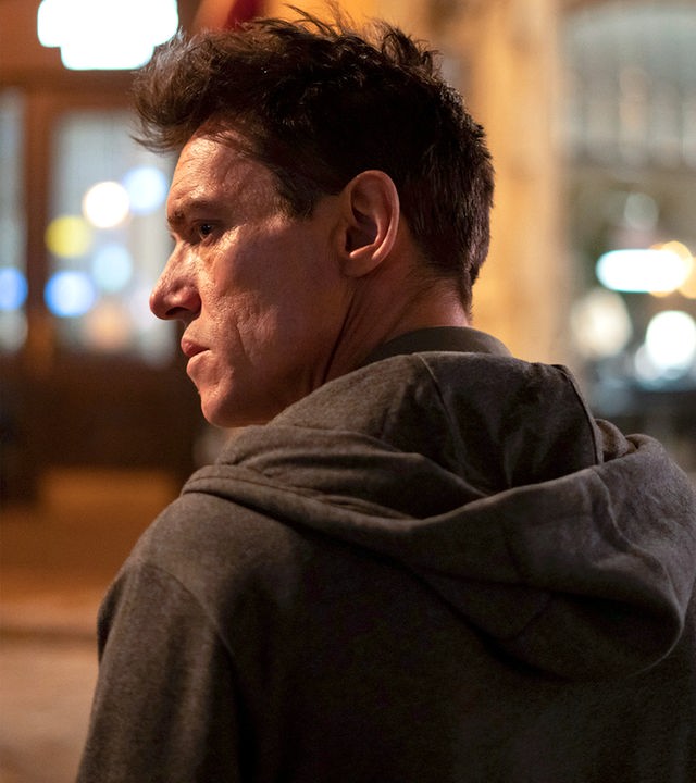 "The Good Neighbor": Nahaufnahme: Robert (Jonathan Rhys Meyers) steht von der Kamera abgekehrt und mit finsterem Blick in nächtlicher Straße.