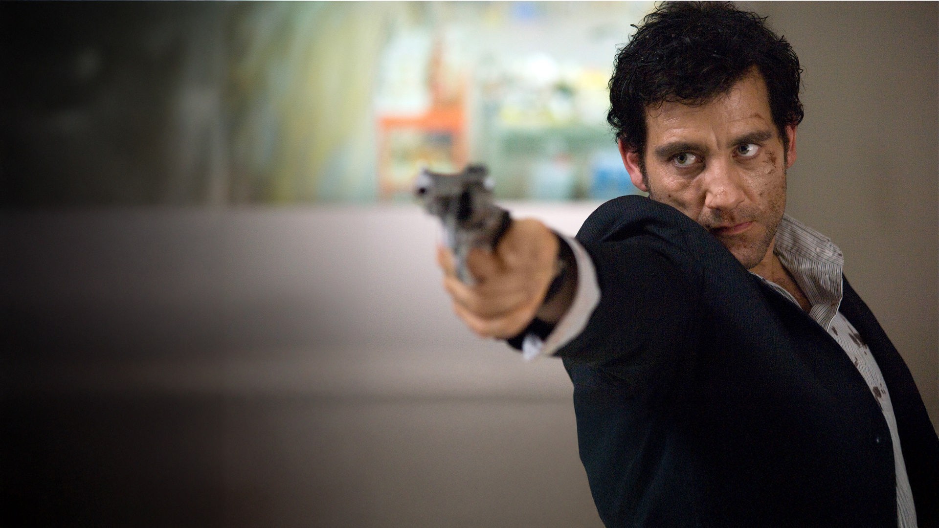 Louis Salinger (Clive Owen) zielt mit einem Revolver auf die Kamera