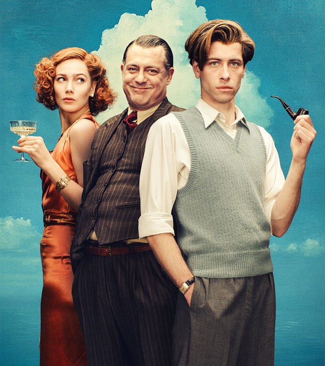 René Magritte (Pierre Gervais), Elt Mesens (Geert Van Rampelberg) und Sheila Legge (Lauren Versnick) stehen vor einem gemalten Himmel mit Wolken im Stil von René Magritte.