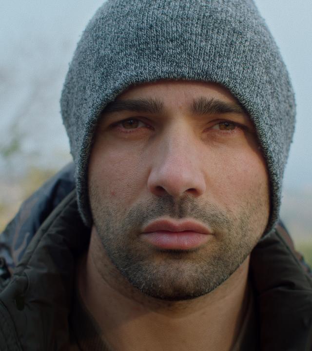 Angelo schaut in die Kamera.