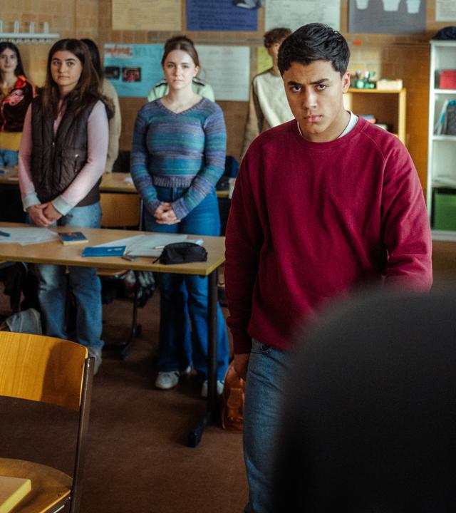 "Uncivilized - Nine Eleven": Ahmad (Rasmi Mohammed Nasrallah) verlässt wütend den Klassenraum, während seine Mitschülerinnen und Mitschüler mit gefalteten Händen an Ihren Plätzen stehen.